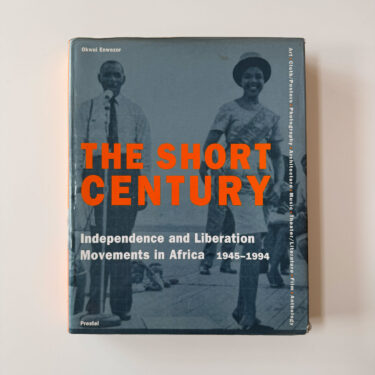 Front cover of the book "The Short Century: Independence and Liberation Movements in Africa 1945–1994" edited by Okwui Enwezor. The cover features a blue-toned photograph of a man and a woman in mid-century attire with bold orange typography.